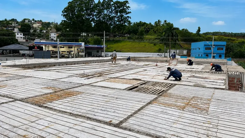Equipe instalando vigotas de laje pré-moldada em uma obra