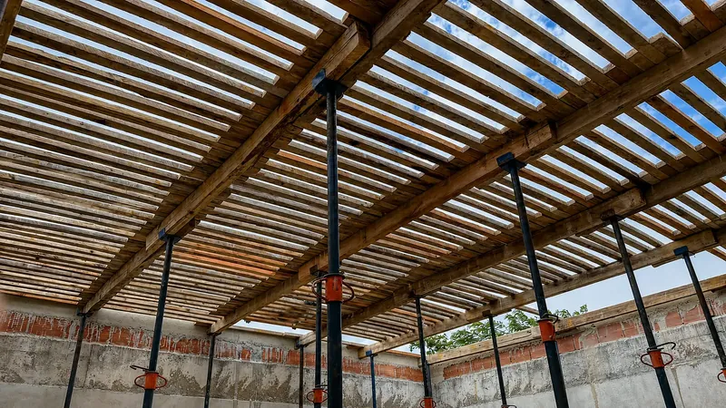 Escoramento de madeira e escoras metálicas sob a laje em obra